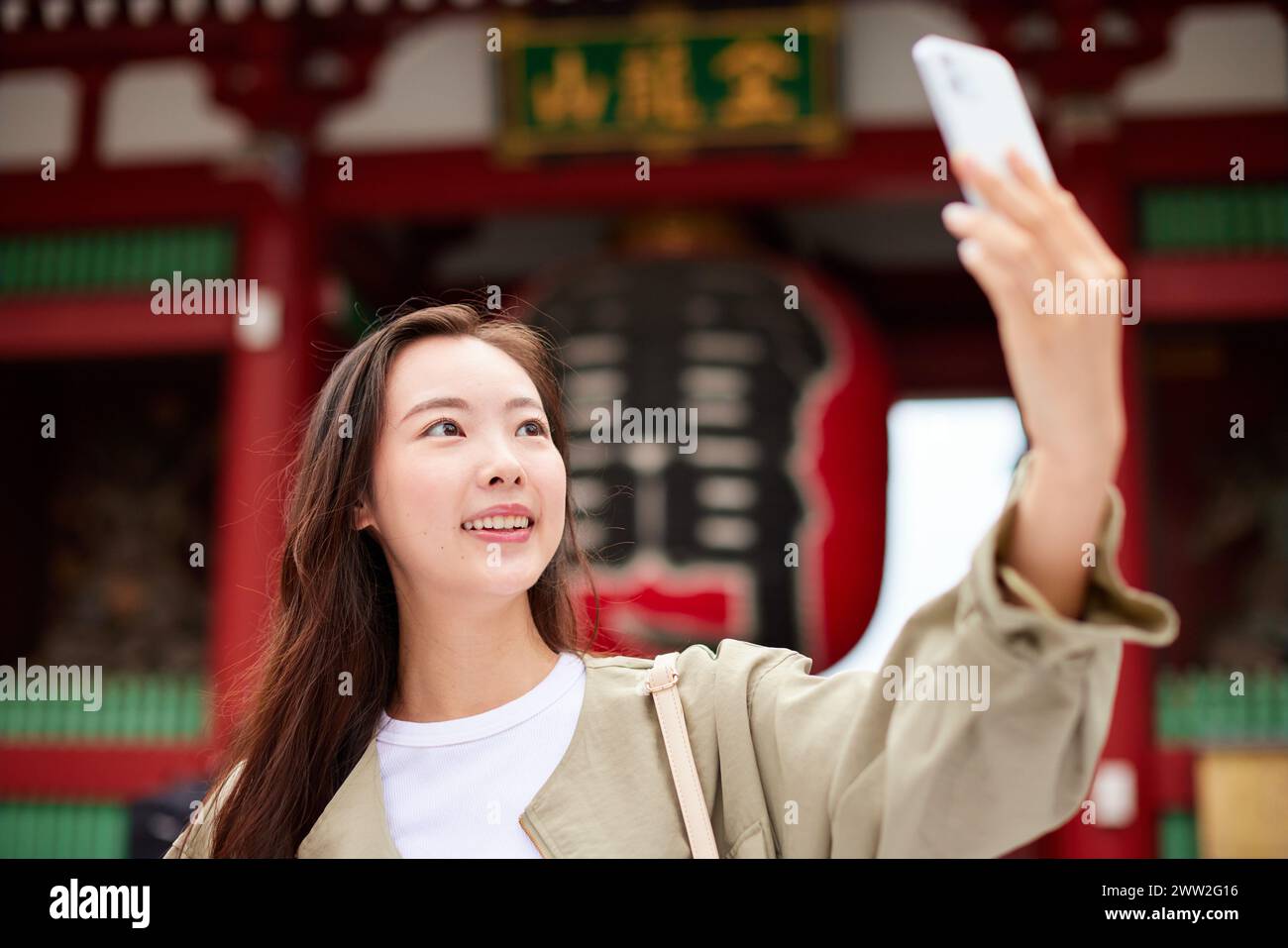 A woman taking a selfie in front of a temple Stock Photo