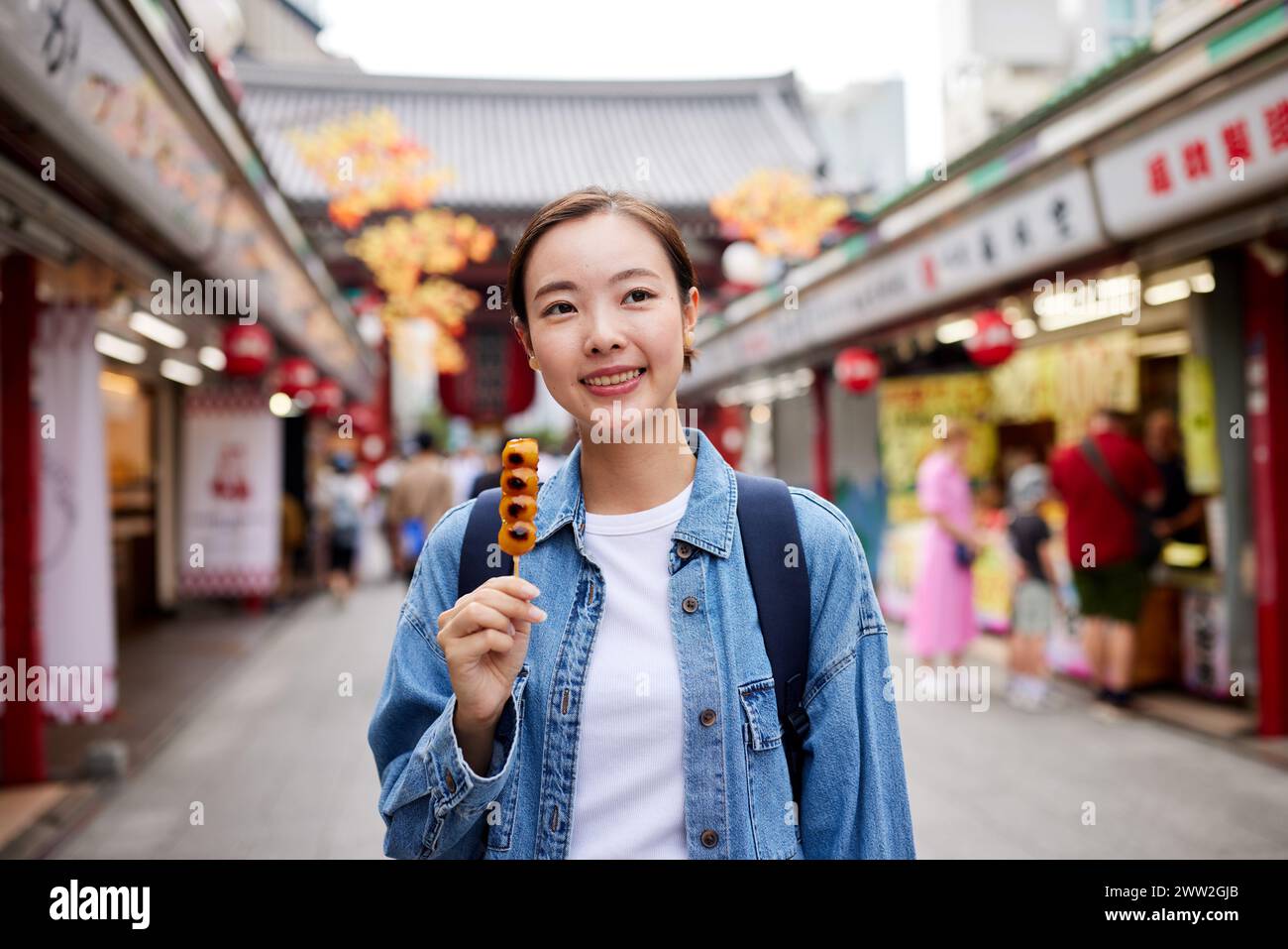 Asian woman eating street food at the temple Stock Photo