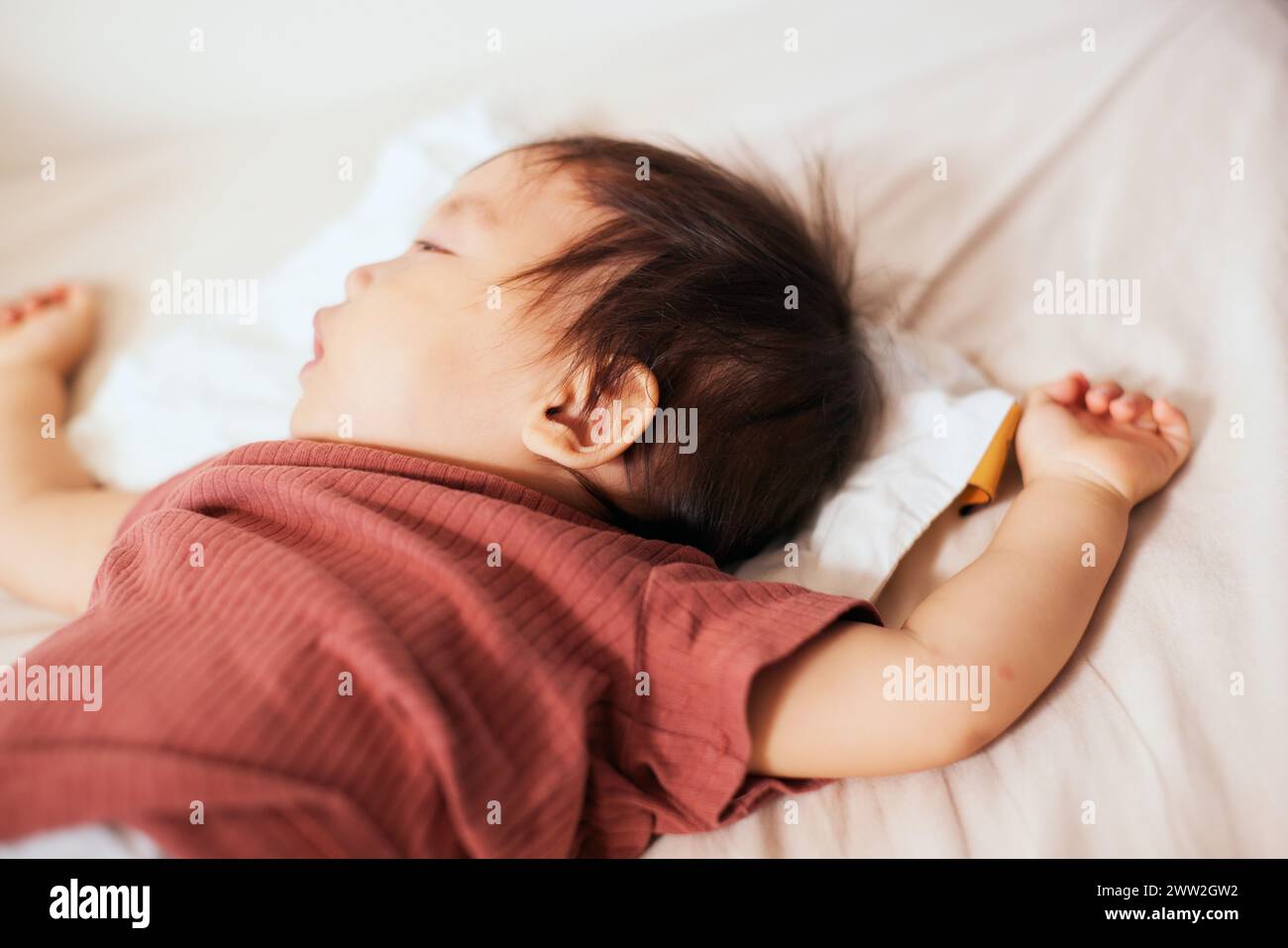 Asian baby sleeping in bed Stock Photo