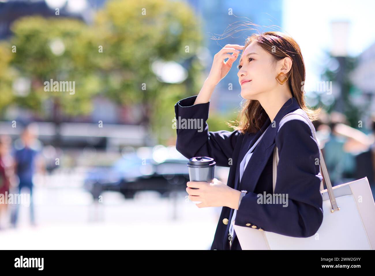 A woman in a business suit holding a coffee cup Stock Photo