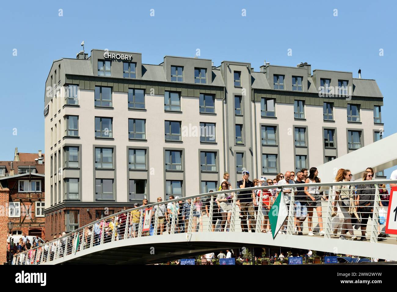 People on Wartka Bridge crossing over Motlawa River by the Chrobry Aparthotel in the Old Town of Gdansk, Poland, Europe, EU Stock Photo