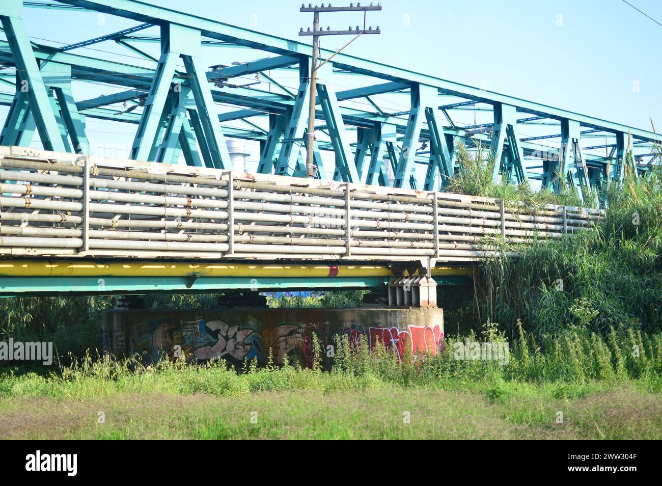Fotografía de un paisaje ferrovial donde la vía del tren pasa sobre el puente de ácero. Stock Photo