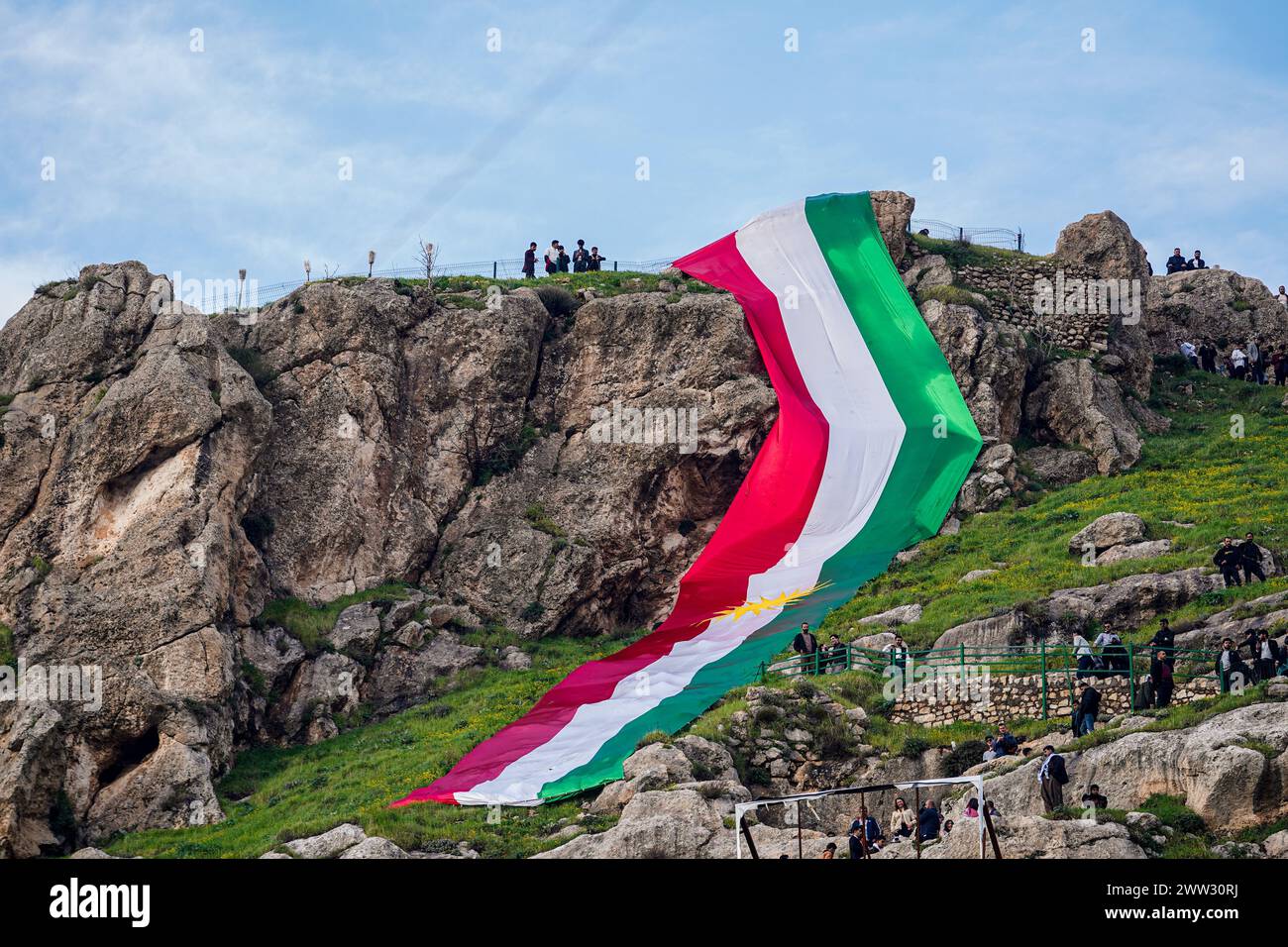 Akre, Iraq. 20th Mar, 2024. Iraqi Kurds hold a huge Kurdistan flag as ...