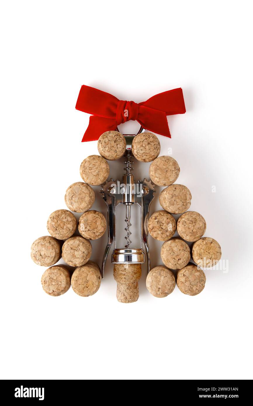 Metal corkscrew and wine corks lined up in the shape of a pyramid Christmas tree with a red bow at the top are isolated on a white background Stock Photo