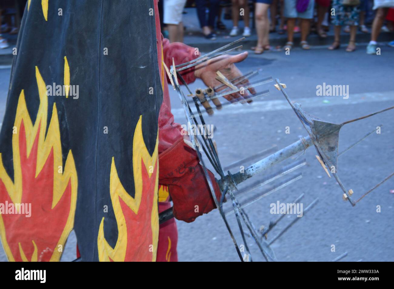 En la fotografía se puede ver la celebración de un Correfocs en el barrio de Grácia. Personas disfrazadas de demonios disparando fuegos artificiales. Stock Photo