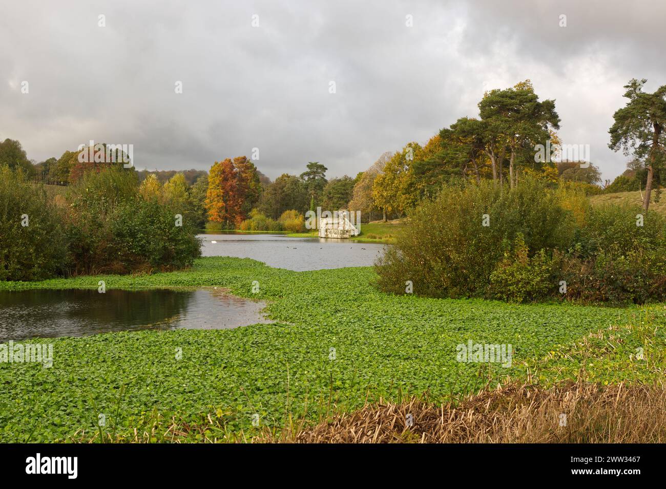English country house grounds. Lake with boathouse. Stock Photo