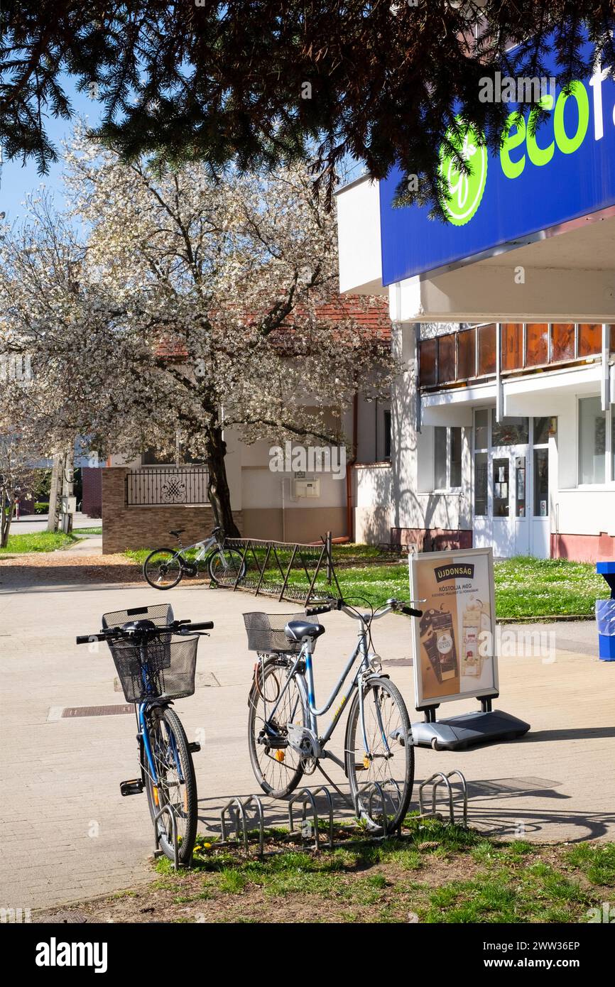 bicycles in cycle rack outside of eco family mini market store lenti zala county hungary Stock Photo
