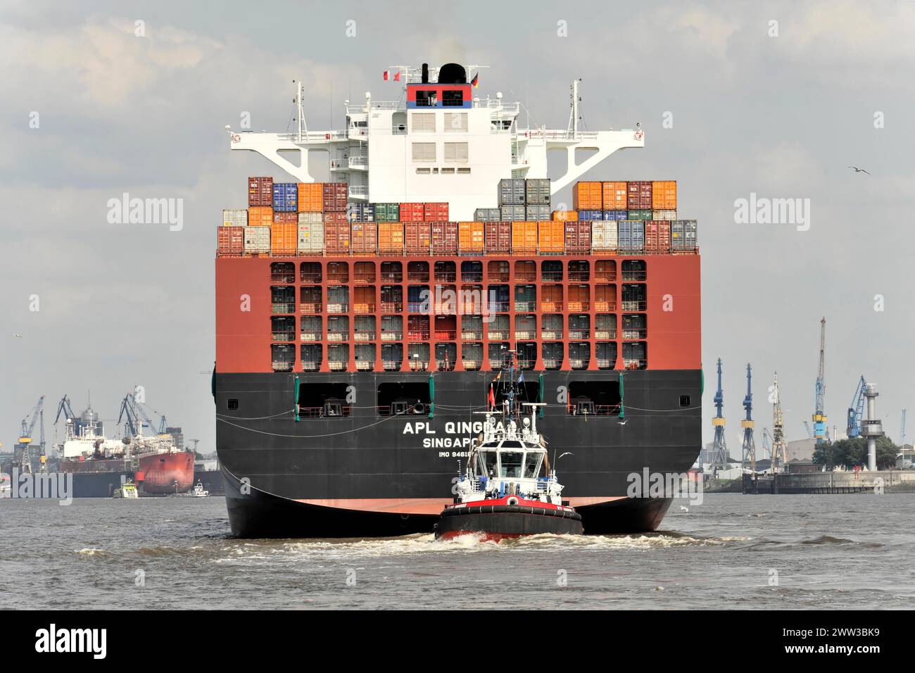 APL QINGDAO, stern of a large container ship on the Elbe, supported by a tugboat, Hamburg, Hanseatic City, Germany Stock Photo