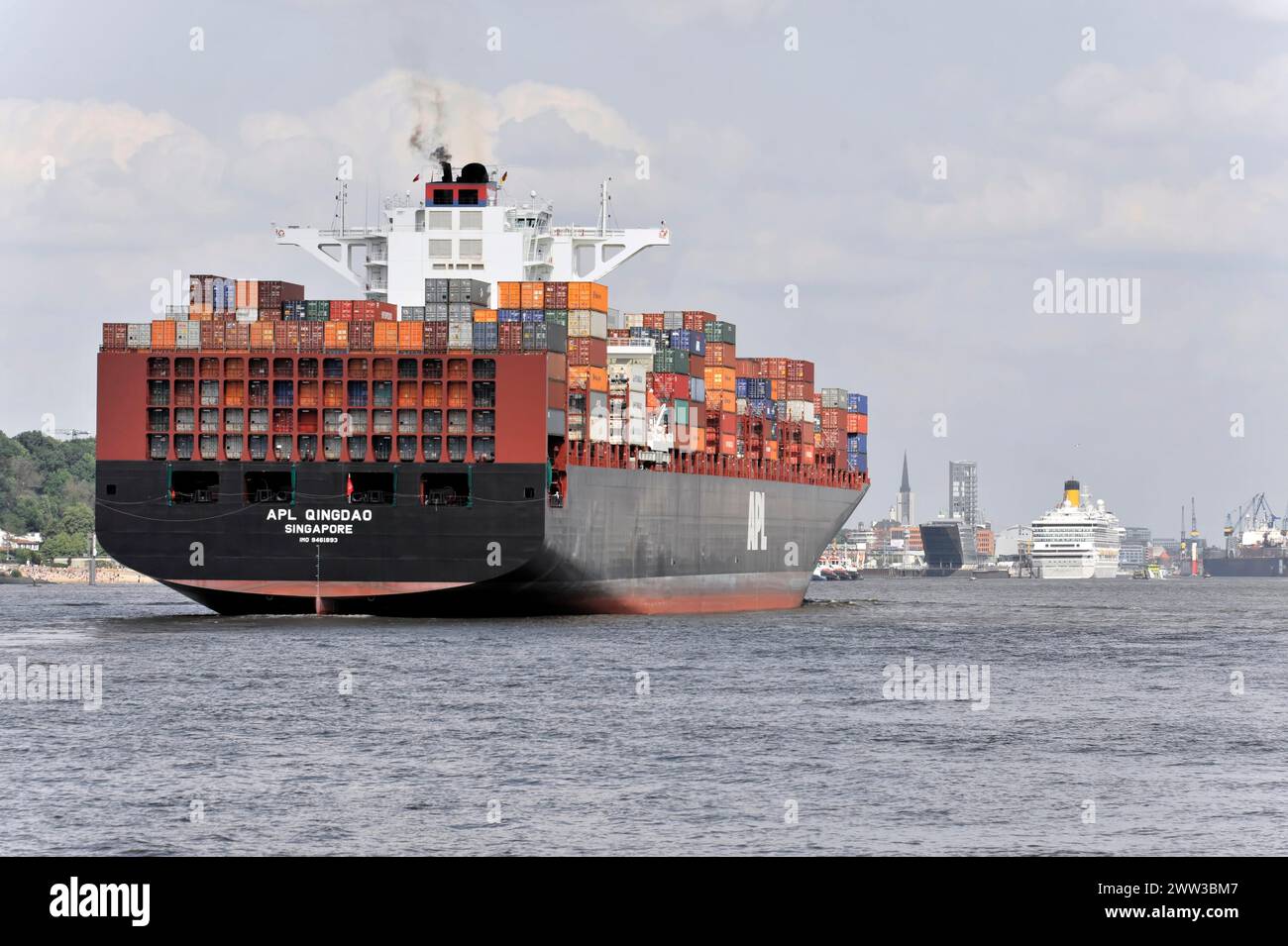 APL QINGDAO, Container ship on the river Elbe with full cargo load under cloudy sky passes by, Hamburg, Hanseatic City, Germany Stock Photo