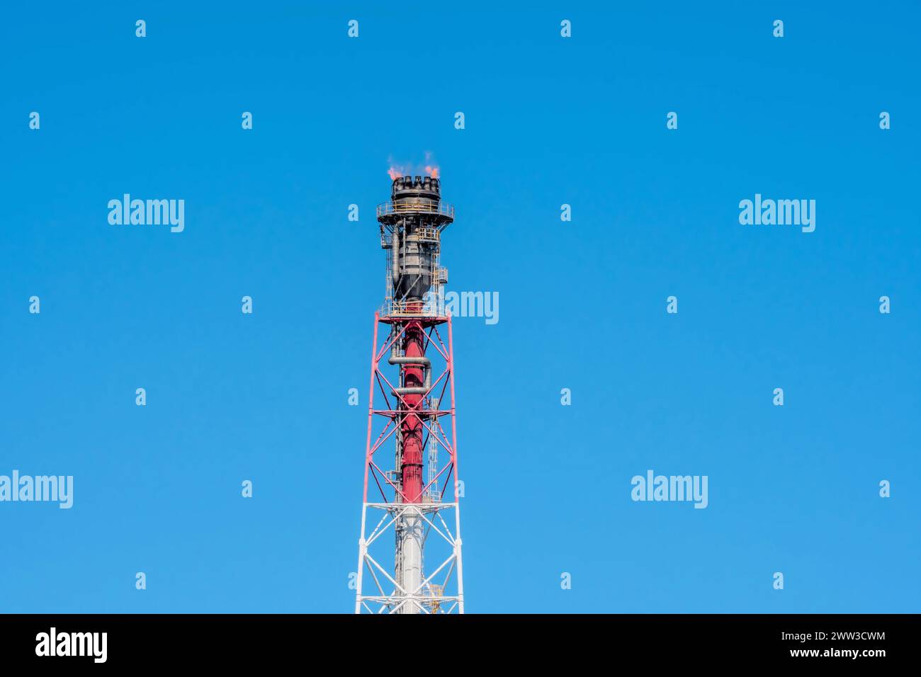 Bluescope Stack Fire Blue sky backdrop with a fierce flame atop an industrial flare stack ...