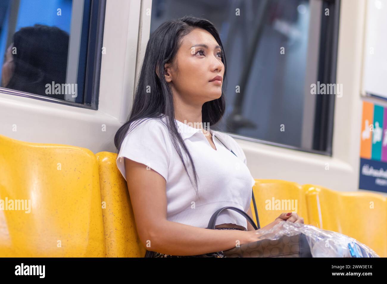 A young woman is sitting in a subway train Stock Photo