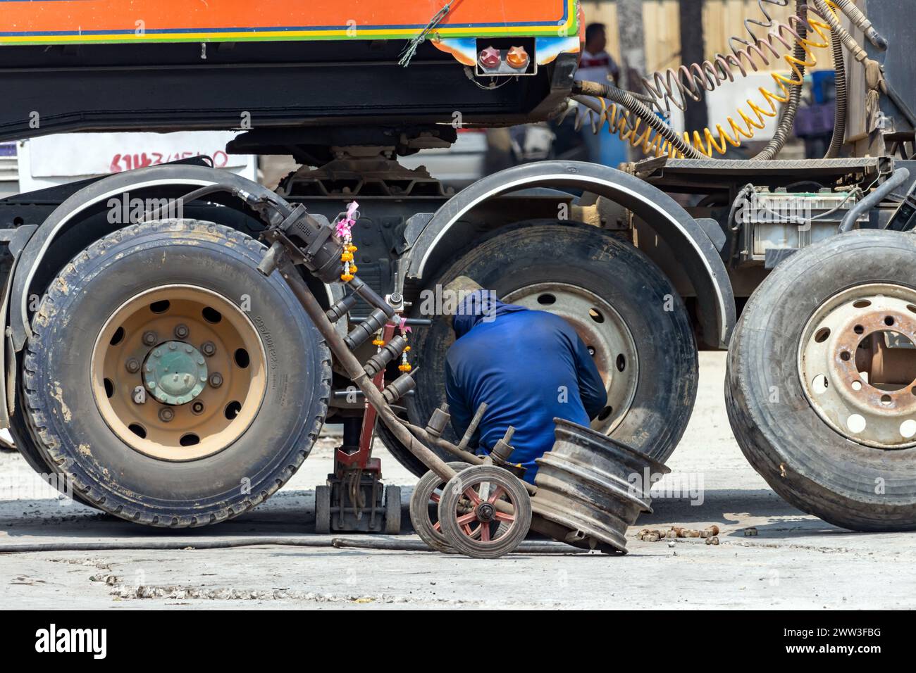 A man is changing a wheel on a truck, Thailand Stock Photo