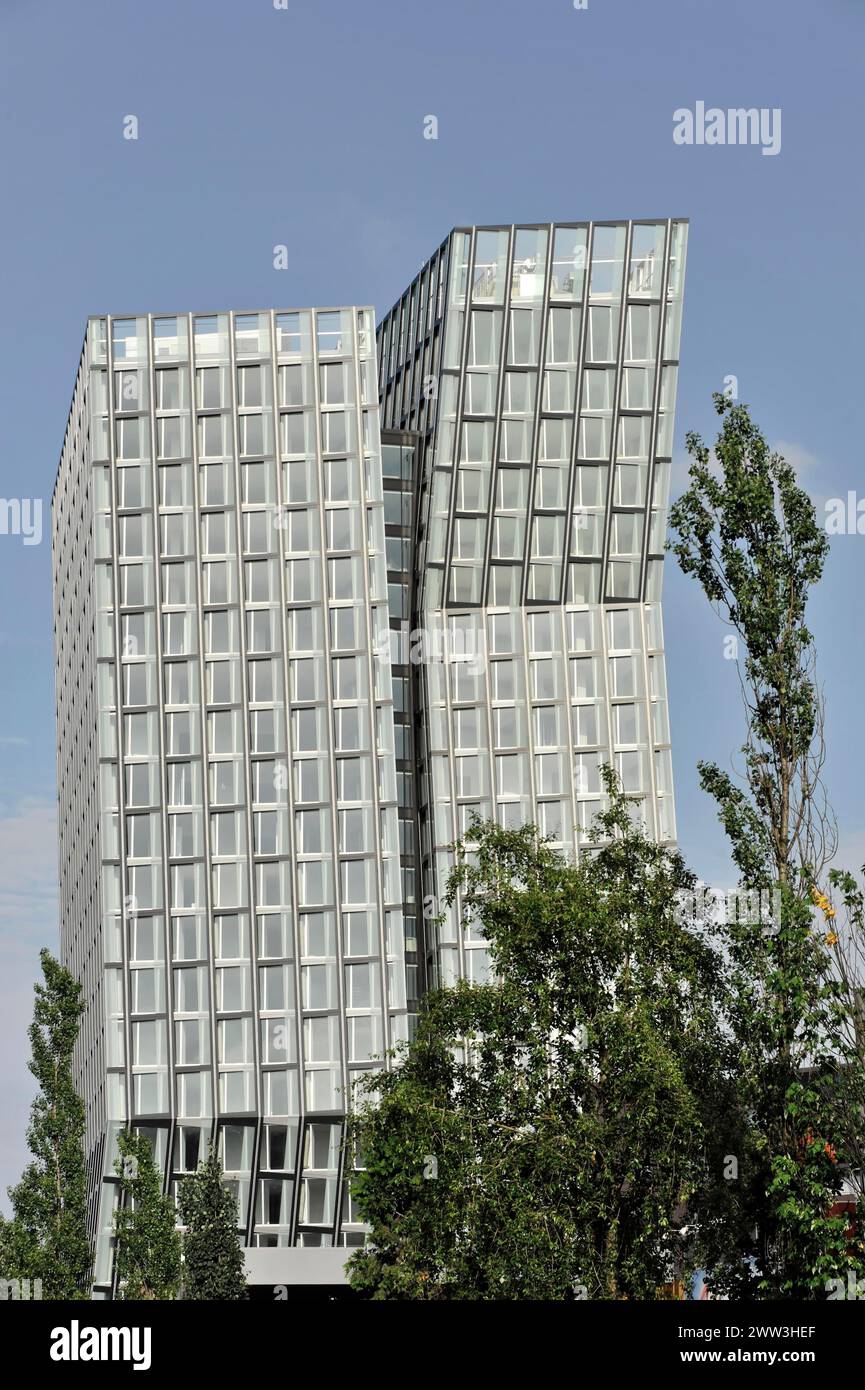 TANZENDE TUeRME, hotel and office building, completed in 2012, angled building with modern glass architecture surrounded by nature and sky, Hamburg Stock Photo