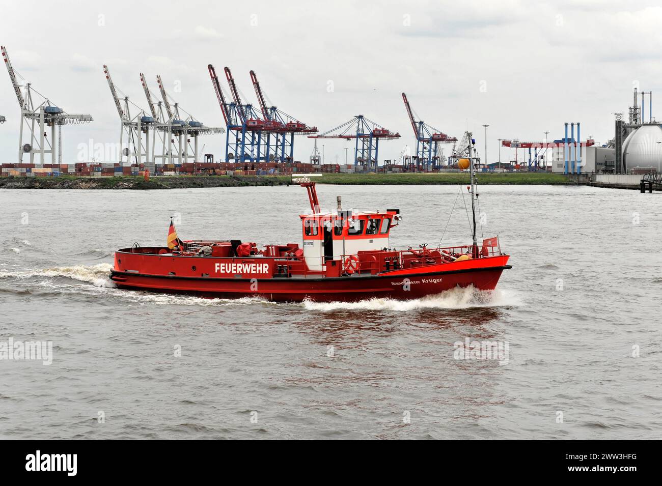 A red fire boat sailing through the water in Hamburg harbour, Hamburg, Hanseatic City of Hamburg, Germany Stock Photo
