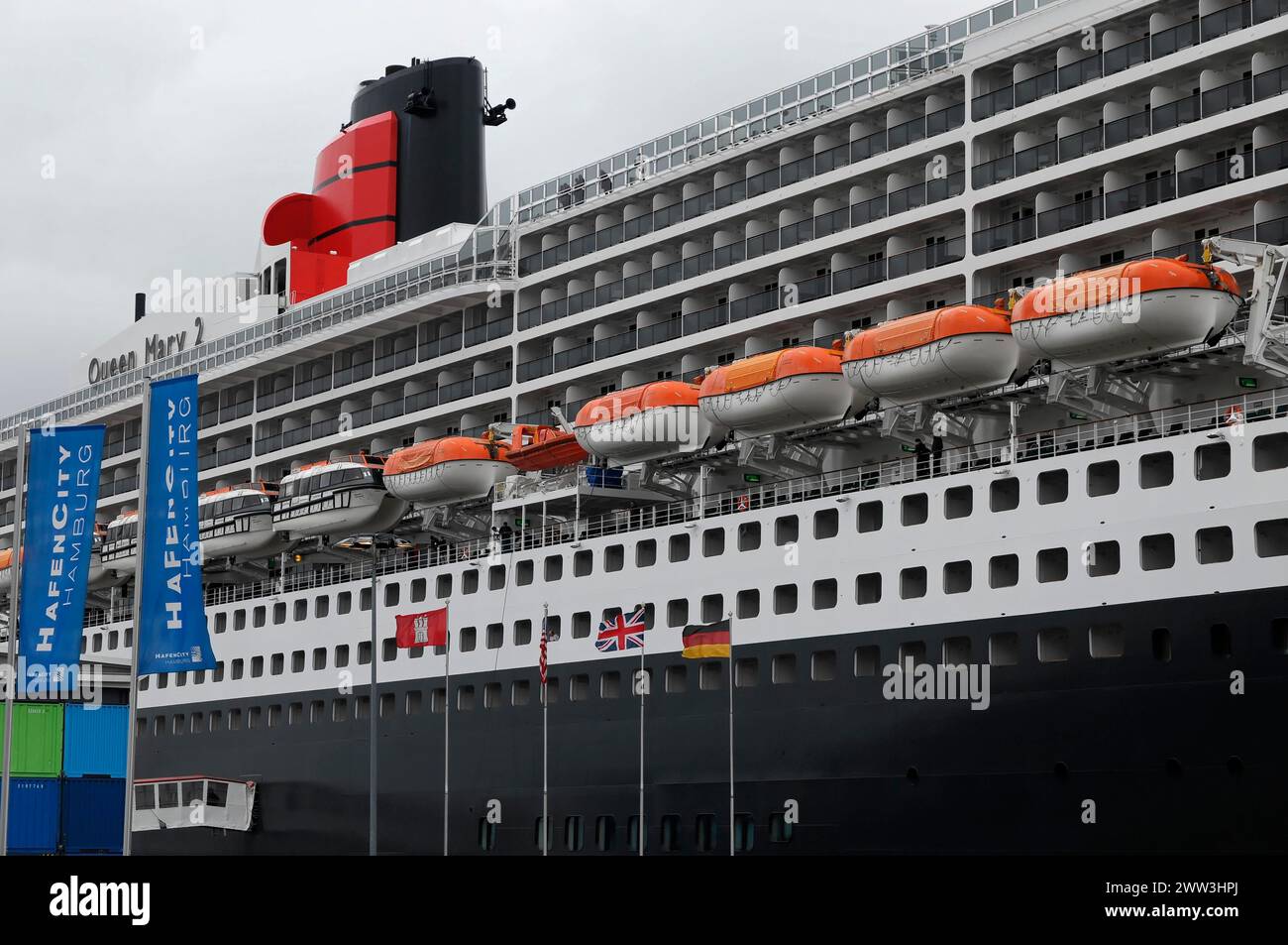 The Queen Mary 2 in the harbour with lifeboats and advertising banners, Hamburg, Hanseatic City of Hamburg, Germany Stock Photo