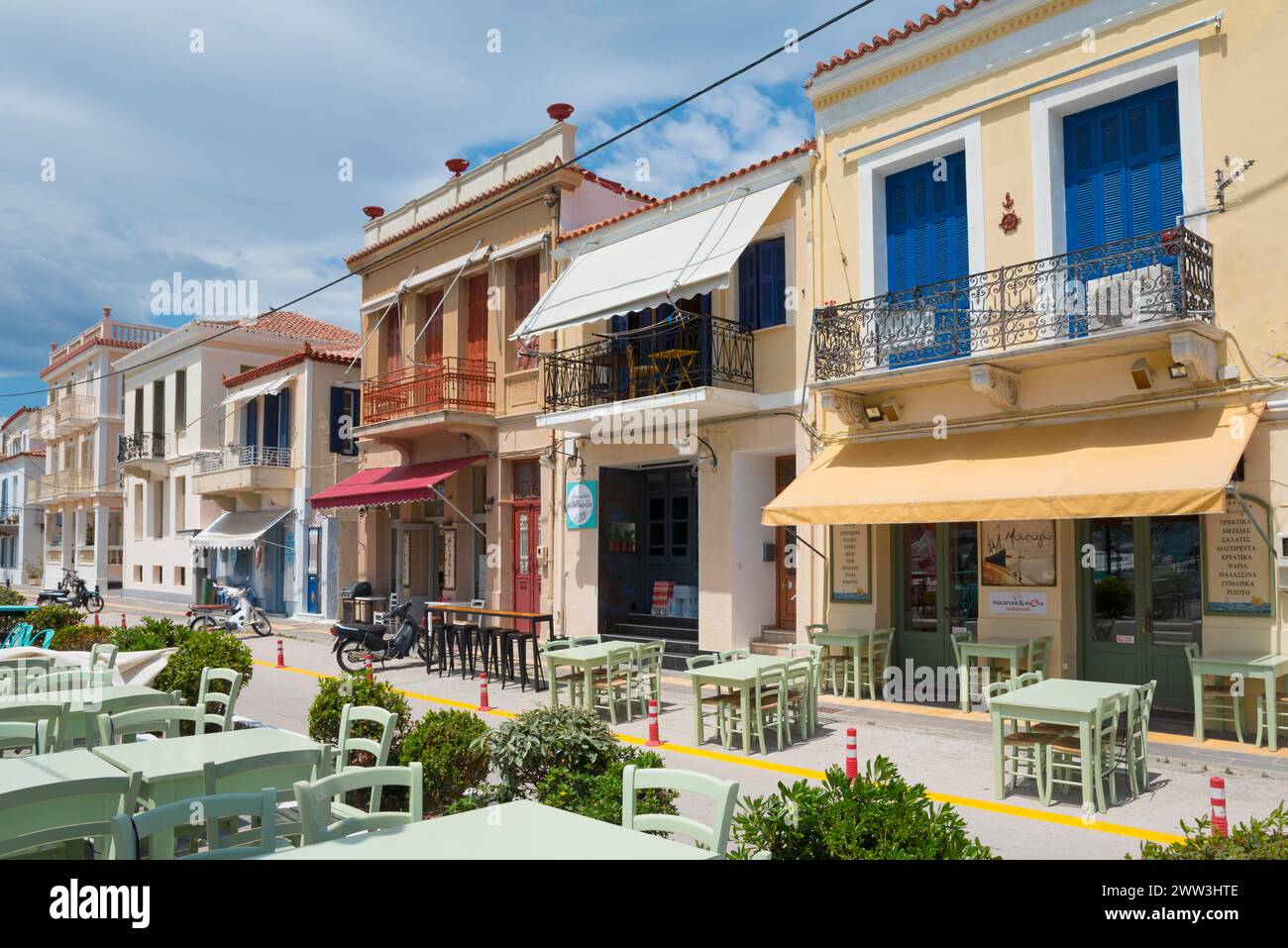 Mediterranean street with colourful buildings, an outdoor restaurant and a clear blue sky, promenade, Poros, Poros Island, Saronic Islands Stock Photo