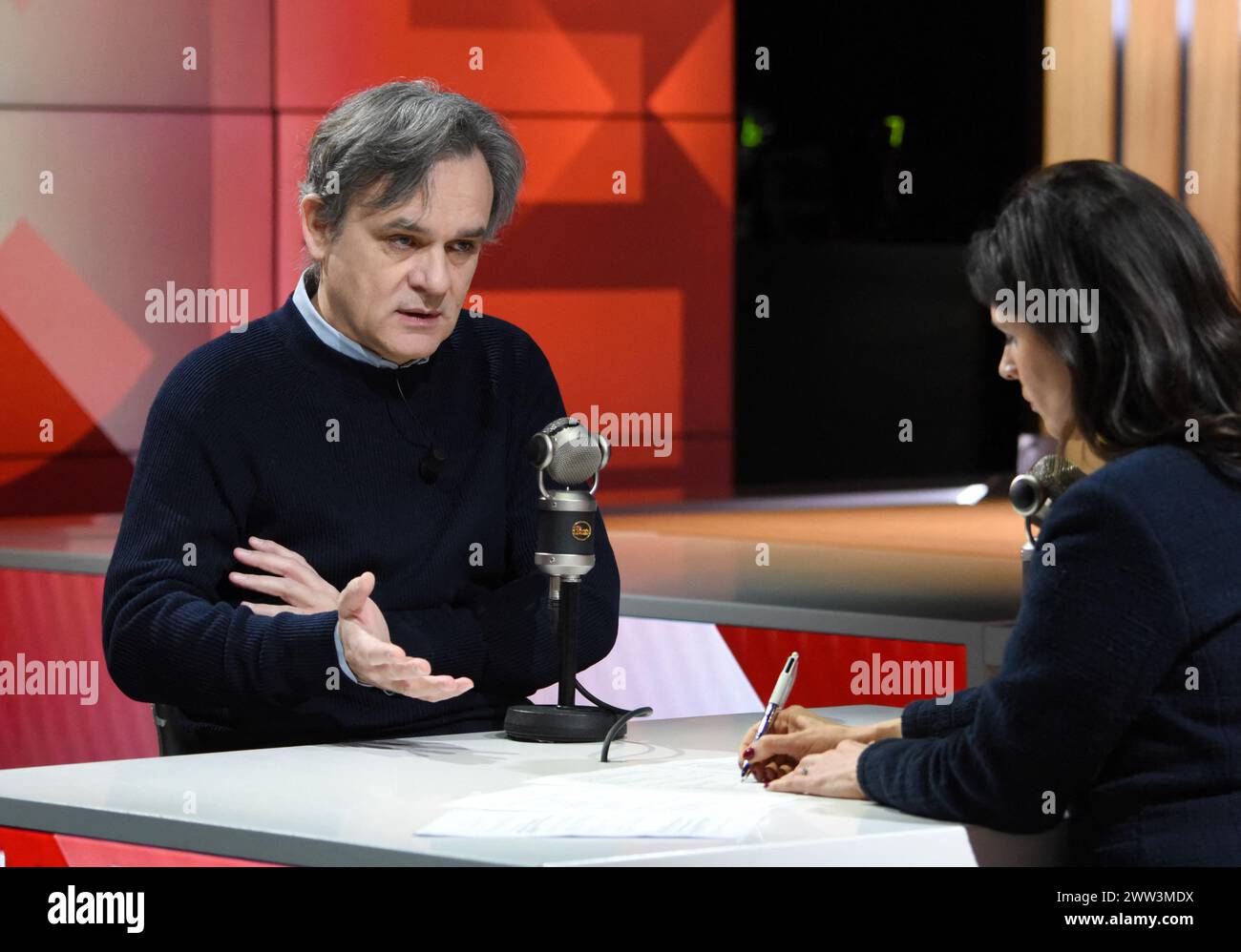 Paris, France. 21st Mar, 2024. Charlie Hebdo director Laurent Sourisseau, know as Riss, is interviewed by Apolline de Malherbe on RMC/BFMTV in Paris, France on March 21, 2024 On January 7, 2015 Sourisseau was shot and wounded in the shoulder during the terrorist attack on the Charlie Hebdo office. From the hospital, he drew four cartoons for the issue of Charlie Hebdo released on 14 January. Riss is now the publishing director of the magazine, and he owns 70 % of the shares. Photo by Alain Apaydin/ABACAPRESS.COM Credit: Abaca Press/Alamy Live News Stock Photo