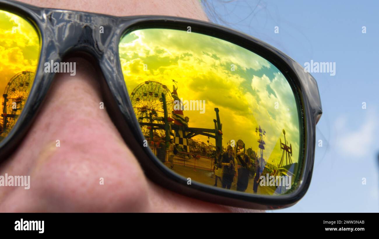 Close-up of an amusement park reflected in the lens of a person's sunglasses Stock Photo