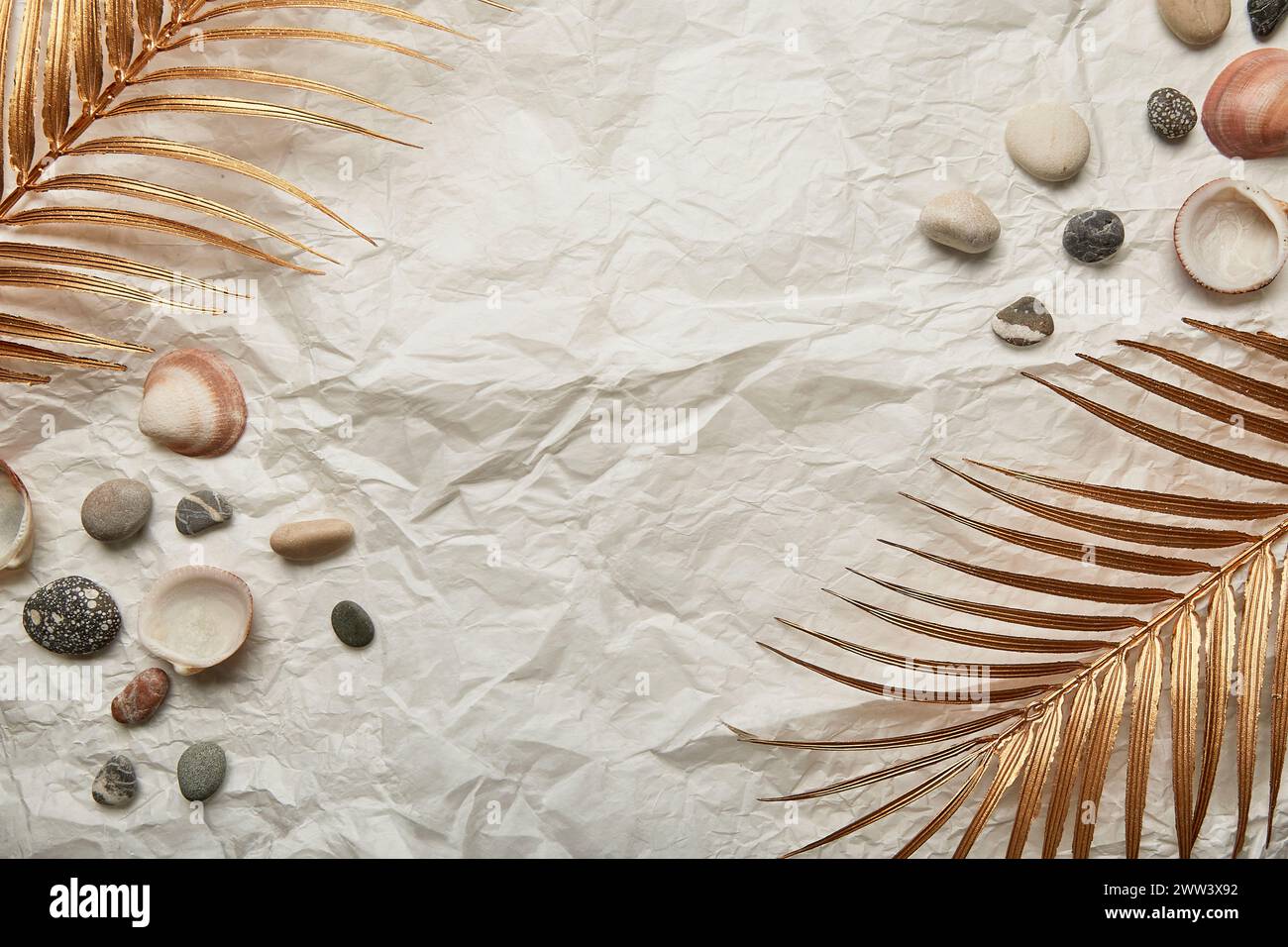 golden palm leaf, pebbles and seashells on summer background with copy space Stock Photo