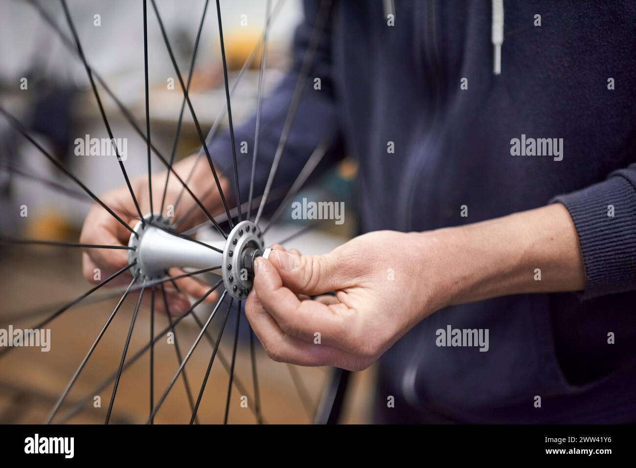 Unrecognizable person assembling a bicycle wheel axle after