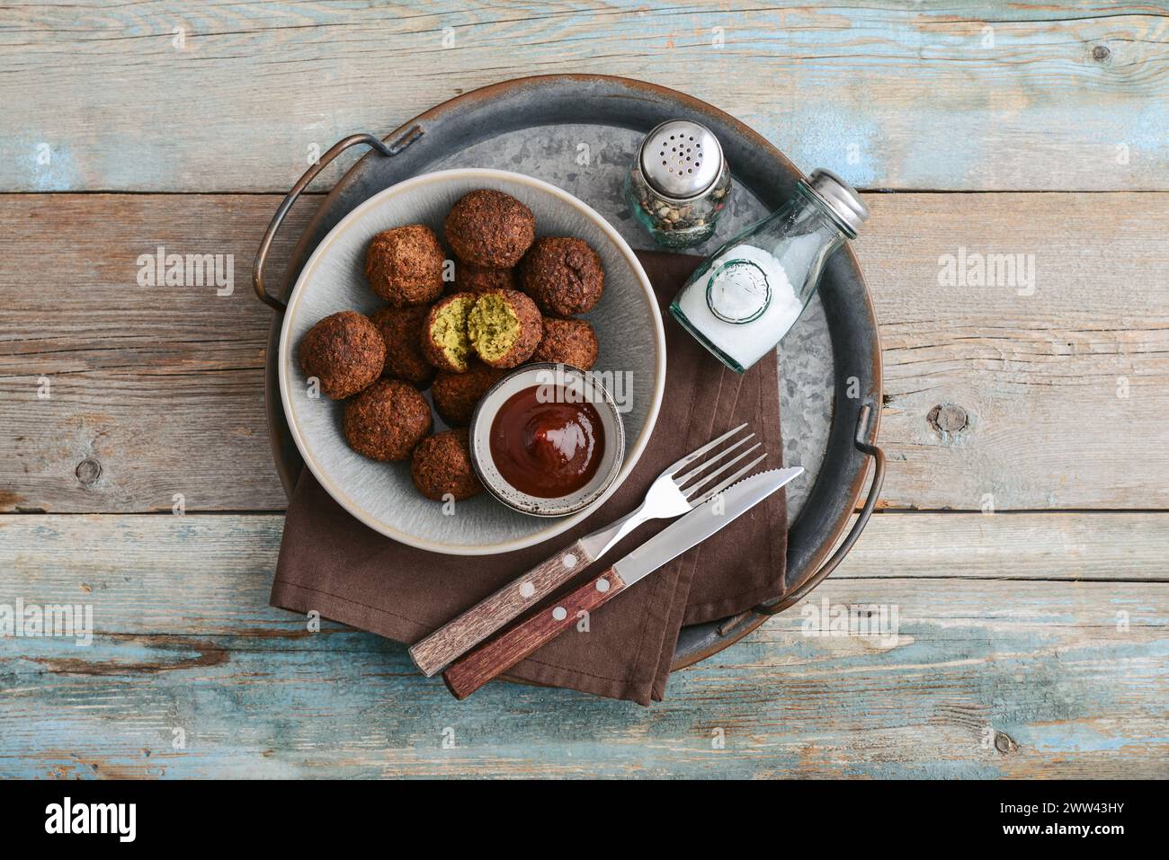 Falafel plate with spice and souce on metal tray on wooden background, top view Stock Photo