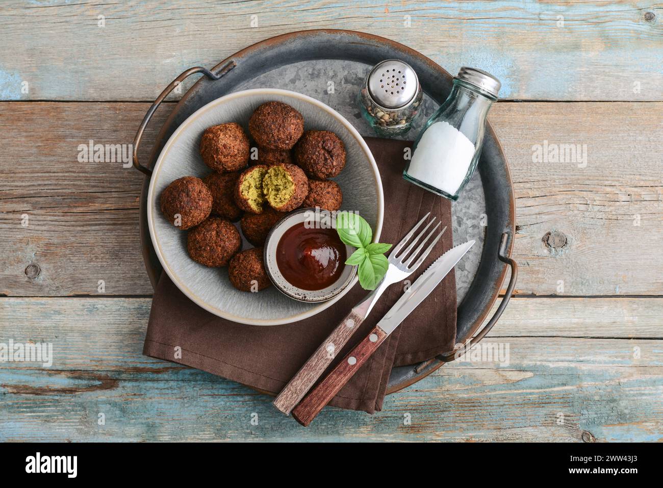 Falafel plate with spice and souce on metal tray on wooden background, top view Stock Photo
