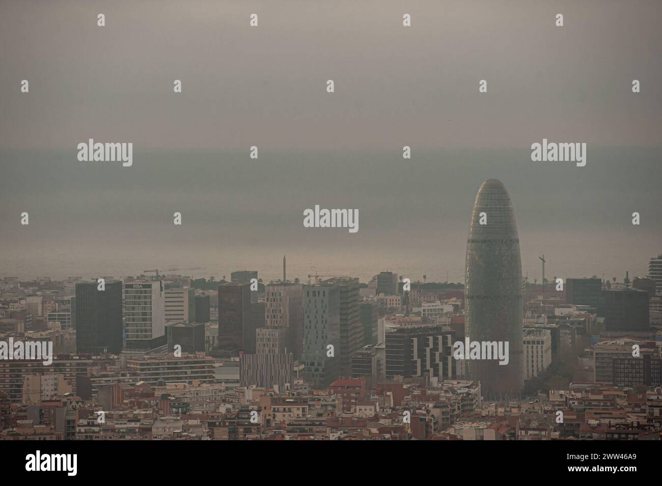 March 21, 2024, Barcelona, Spain: March 21, 2024, Barcelona, Spain: Buildings are seen among Barcelona's area skyline as the sun rises amid haze and clouds. Already into spring, the Spanish meteorological agency (AEMET) has confirmed that this has been the warmest winter in history in Spain since data was taken. Credit: Jordi Boixareu/Alamy Live News Stock Photo