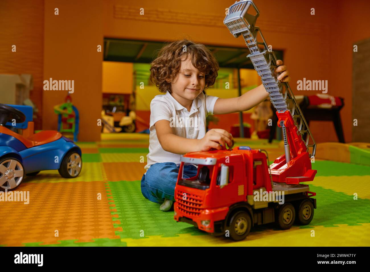 Cute boy child playing vehicle toys at kids care center Stock Photo - Alamy