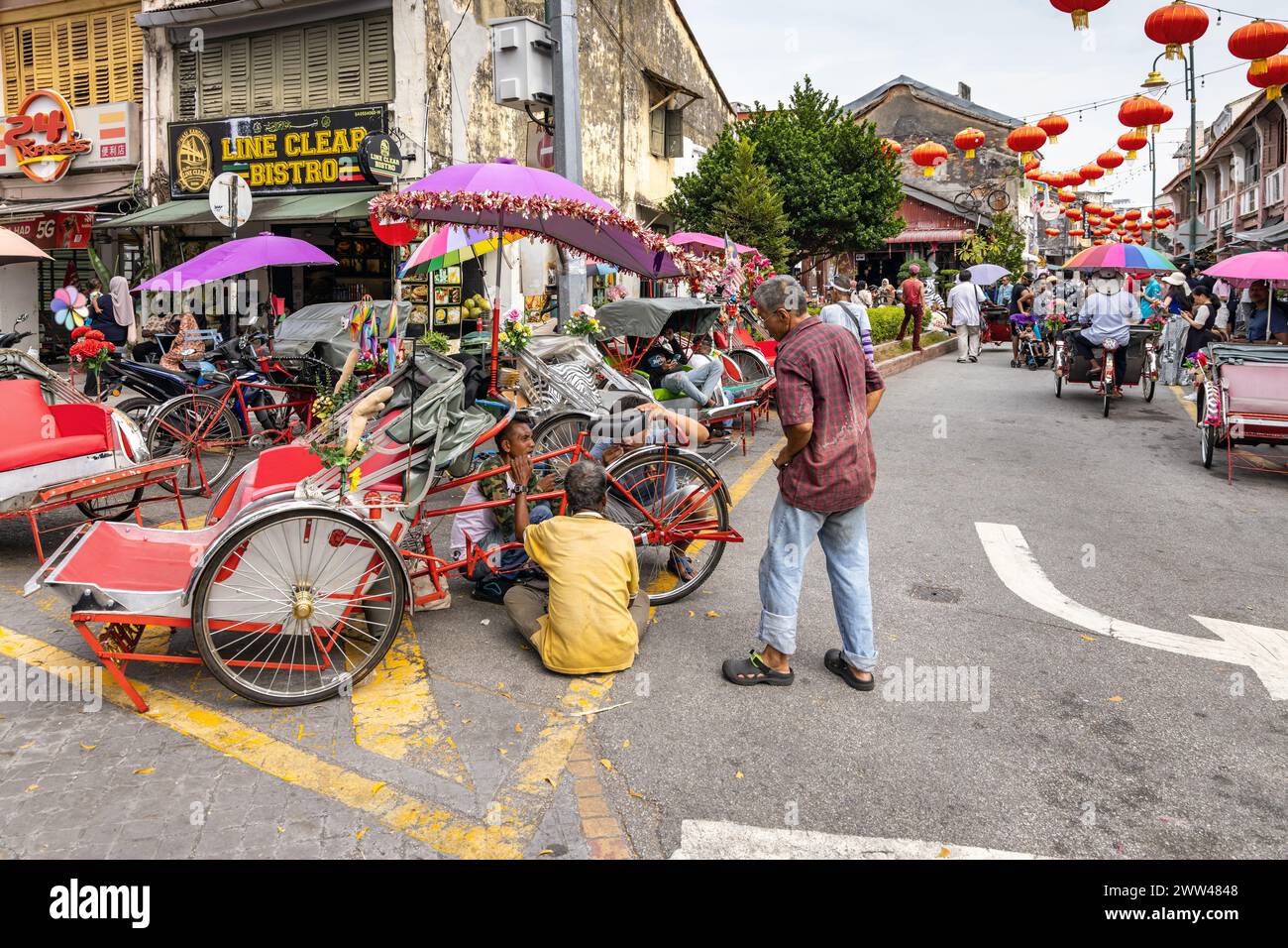 carrying out repairs to Trishaws, or cycle rikshaws, in Georgetown, Penang, Malaysia Stock Photo