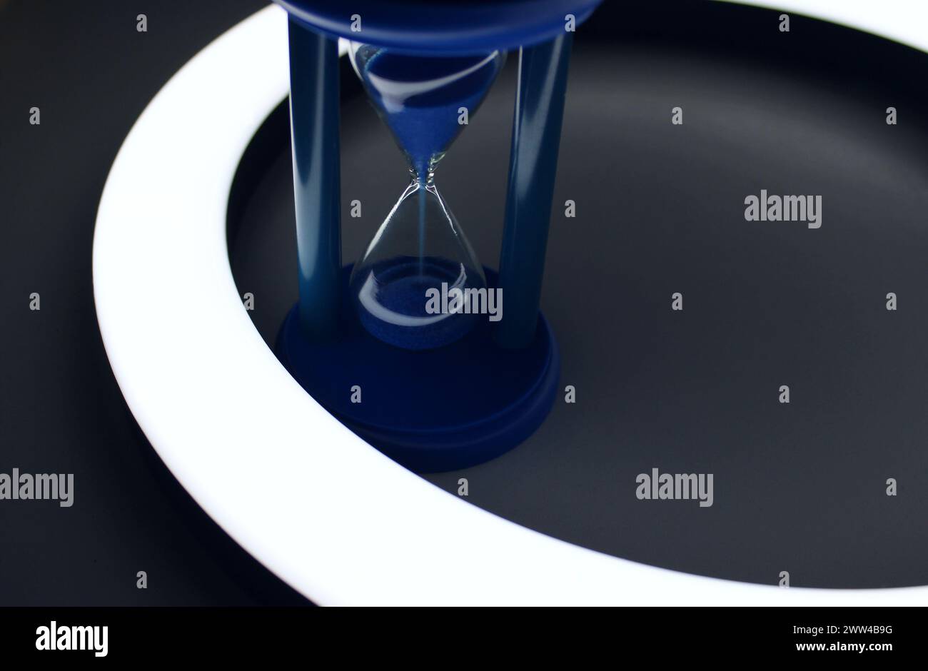 Falling Sand In Blue Hourglass Inside A Ring Of Light Isolated Stock Photo Stock Photo