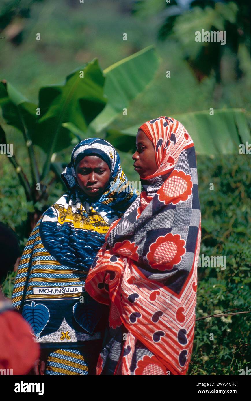 Swahili Women in colourful traditional clothing on the beach in Zanzibar Stock Photo