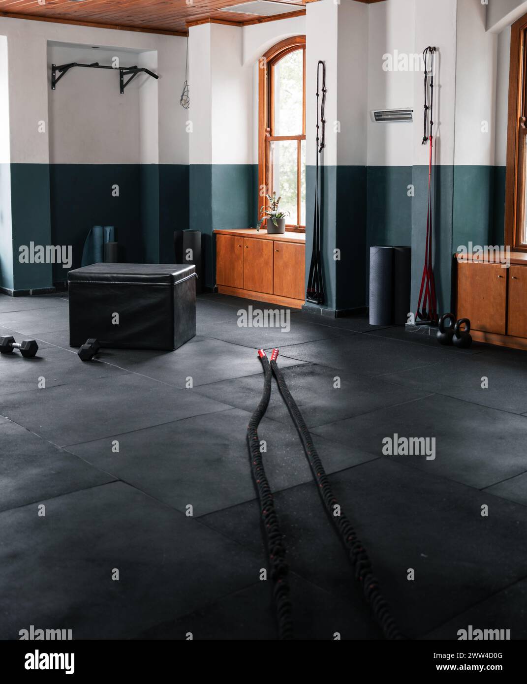 Gym with black hardwood floor and dual ropes for workouts Stock Photo ...