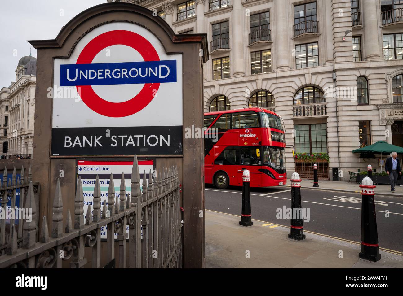 London, UK: An entrance to Bank Underground Station in the City of London. Red bus behind. Stock Photo