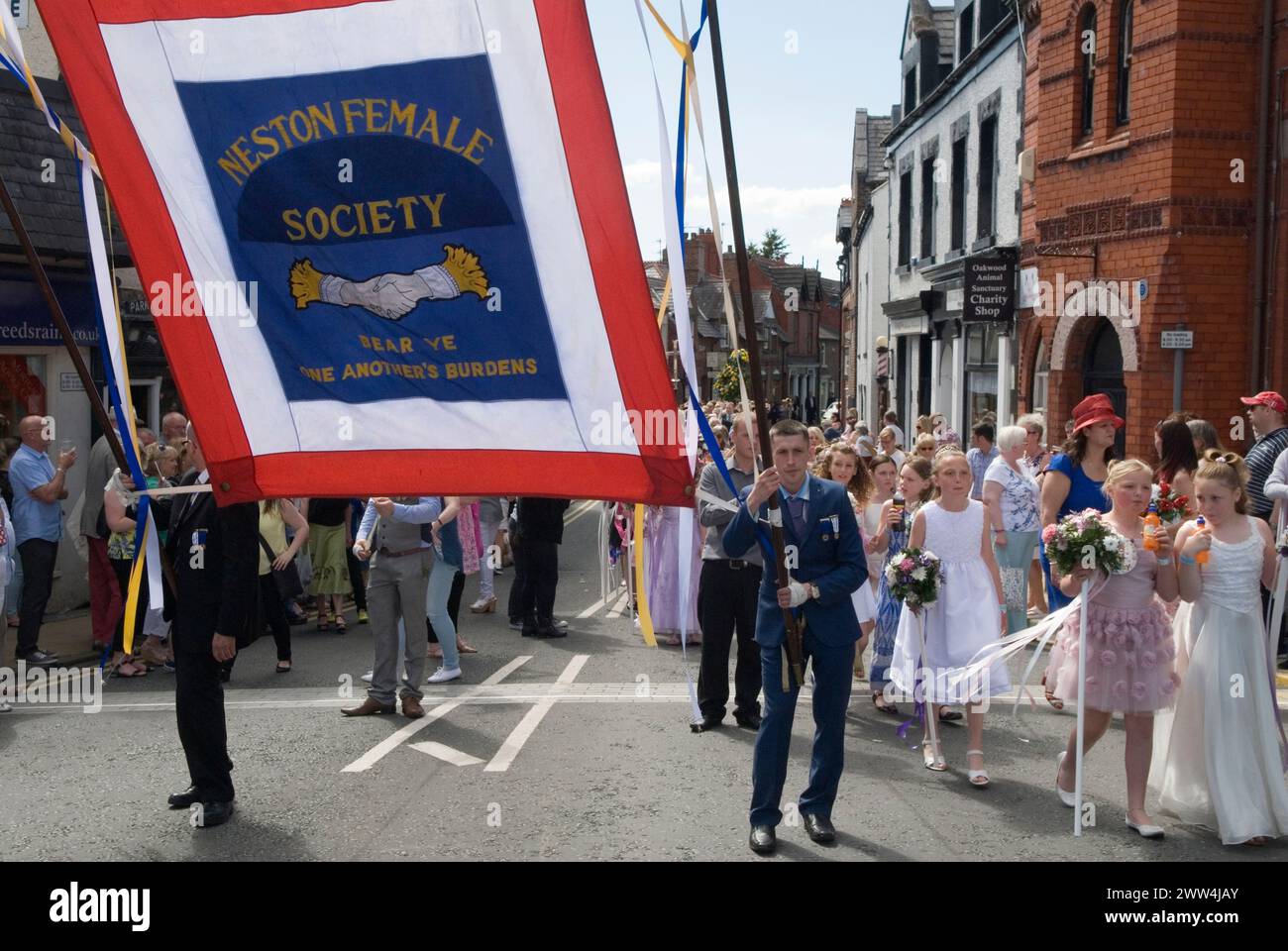 Neston Female Friendly Society Annual Club Walking Day. Ladies and children – girls parade around the village behind the club society banner, “Neston Female Society Bear Ye One Another’s Burdens.”  Neston Cheshire UK 2015. 2010s HOMER SYKES Stock Photo