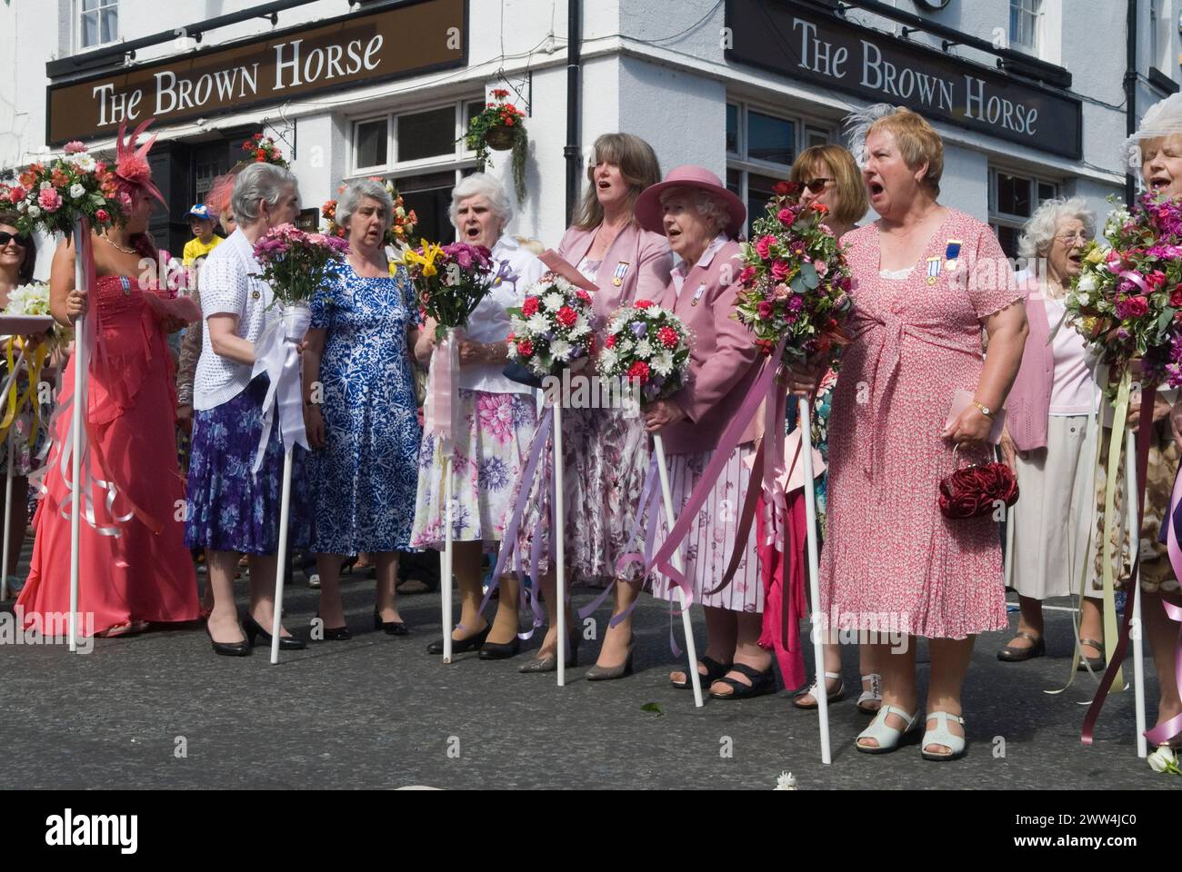 Neston Female Friendly Society Annual Club Walking Day. Ladies Club members at the 'Cross', sing hymns and Land of Hope and Glory. They walk with Flower Sticks. Neston, Cheshire, England 4th June 2015. 2010s UK HOMER SYKES Stock Photo