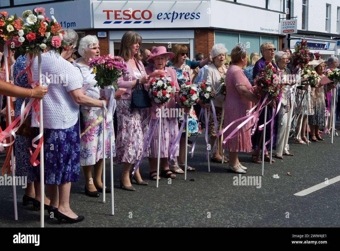 Neston Female Friendly Society Annual Club Walking Day. Neston Cheshire UK 2015. Ladies Club members at the 'Cross' sing hymns and Land of Hope and Glory. They walk with their Flower Sticks. 2010s HOMER SYKES Stock Photo