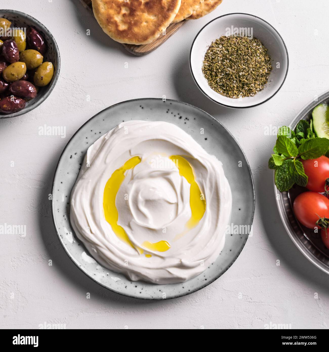 Labneh yogurt cream cheese with olive oil, zaatar, olives, vegetables