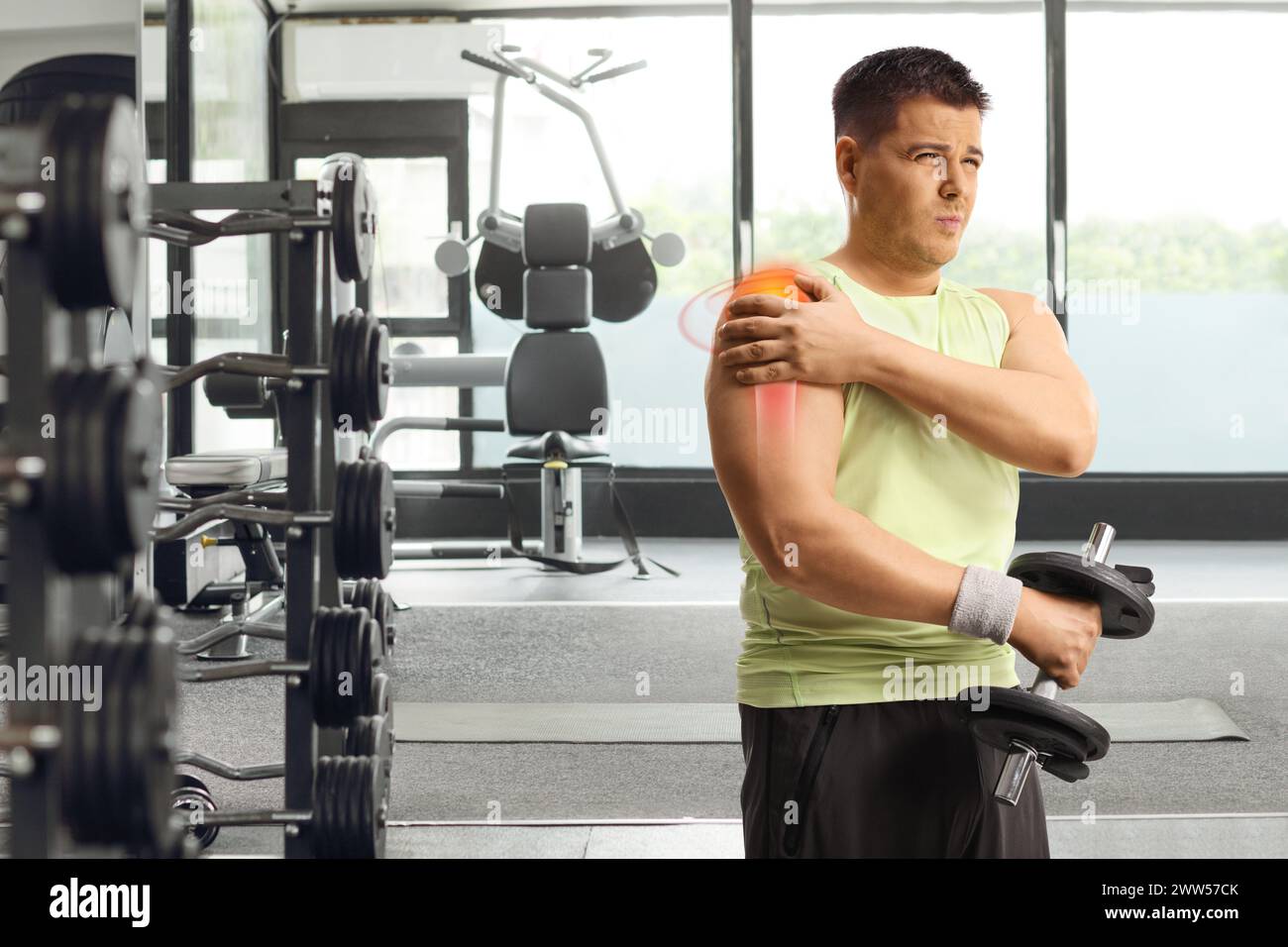 Man with shoulder injury and red inflamed area lifting weights at a gym
