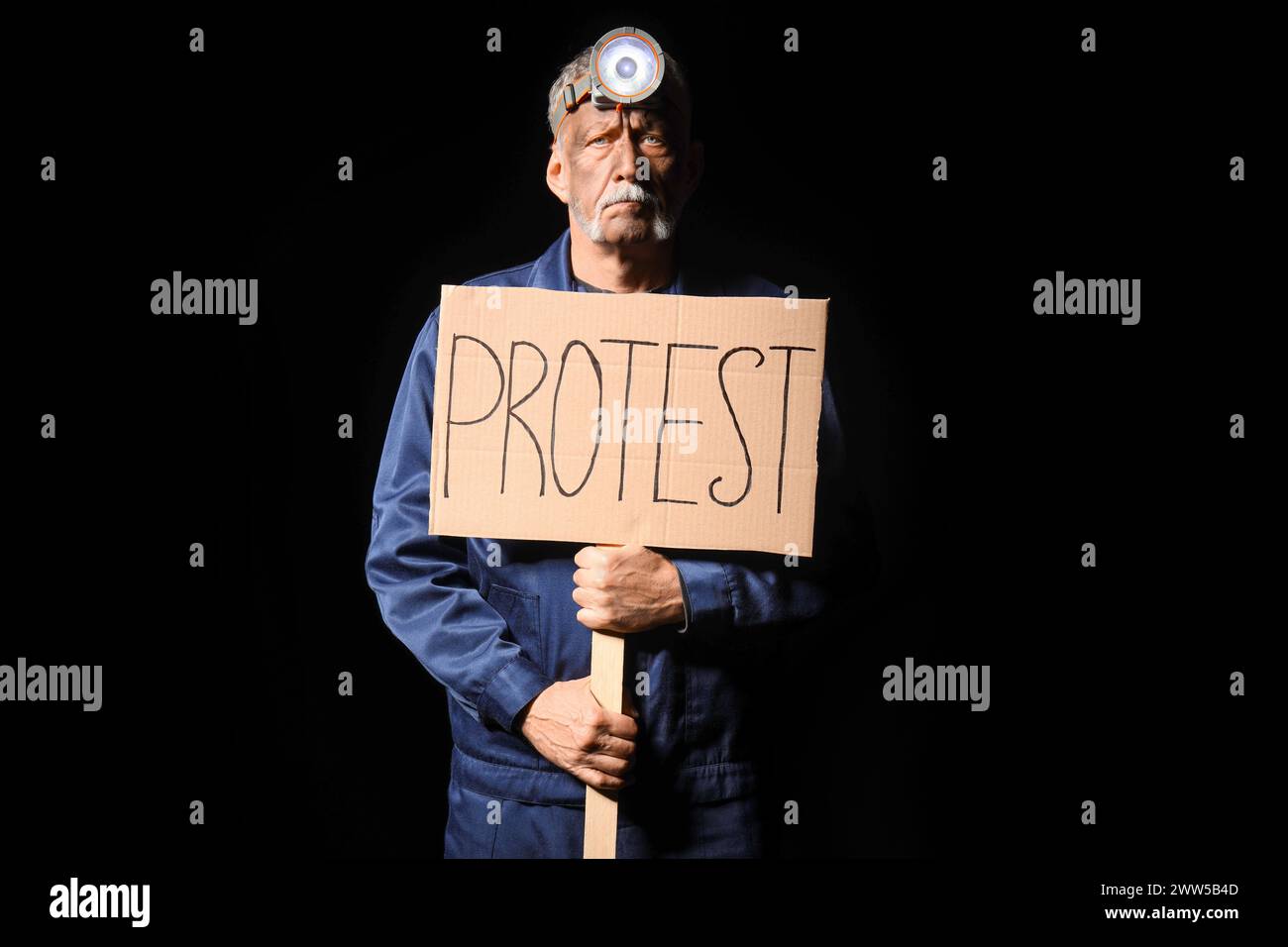 Protesting miner man with placard on black background Stock Photo
