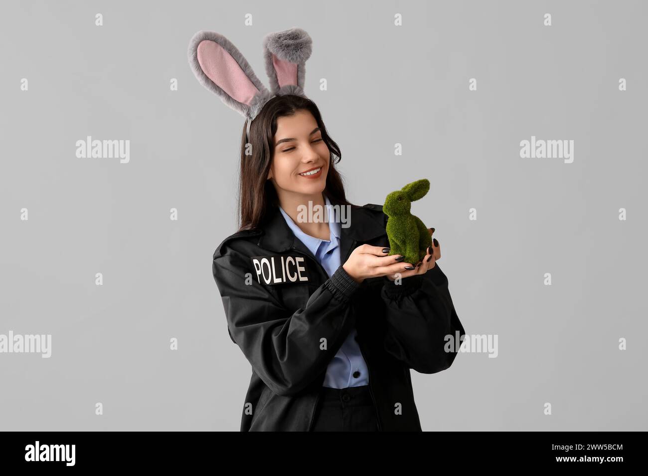 Police Rabbit Easter Female police officer in bunny ears with Easter rabbit on light ...