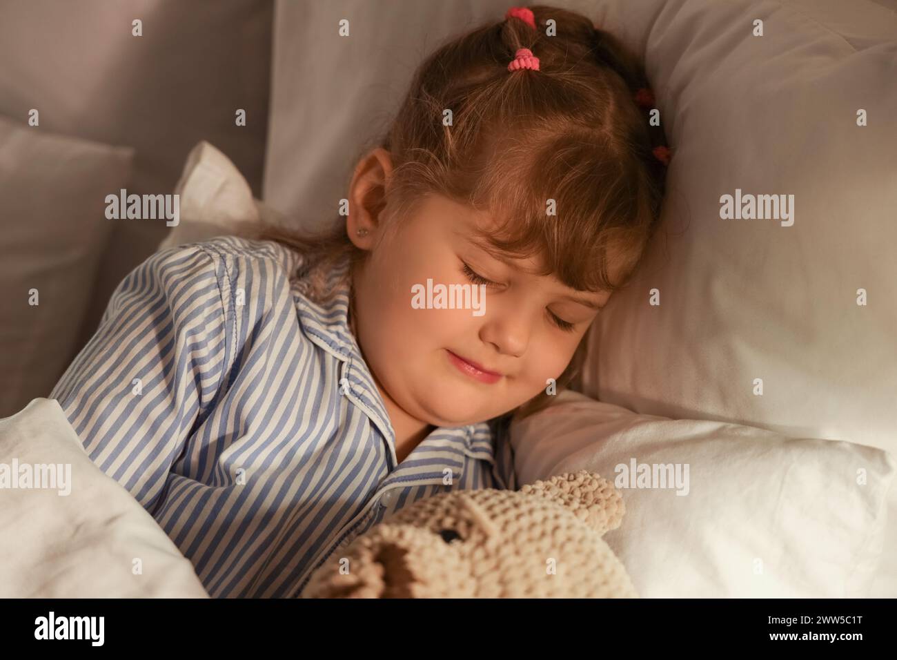 Adorable little girl with teddy bear sleeping in bed Stock Photo - Alamy