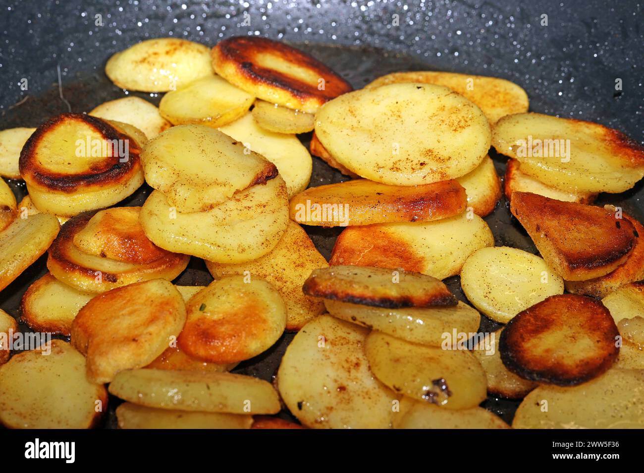 Deftige Mahlzeiten aus der Kartoffel Kartoffeln in heißem Öl während der Zubereitung zu deftigen Bratkartoffeln. *** Hearty meals from the potato Potatoes in hot oil during preparation to make hearty fried potatoes Stock Photo