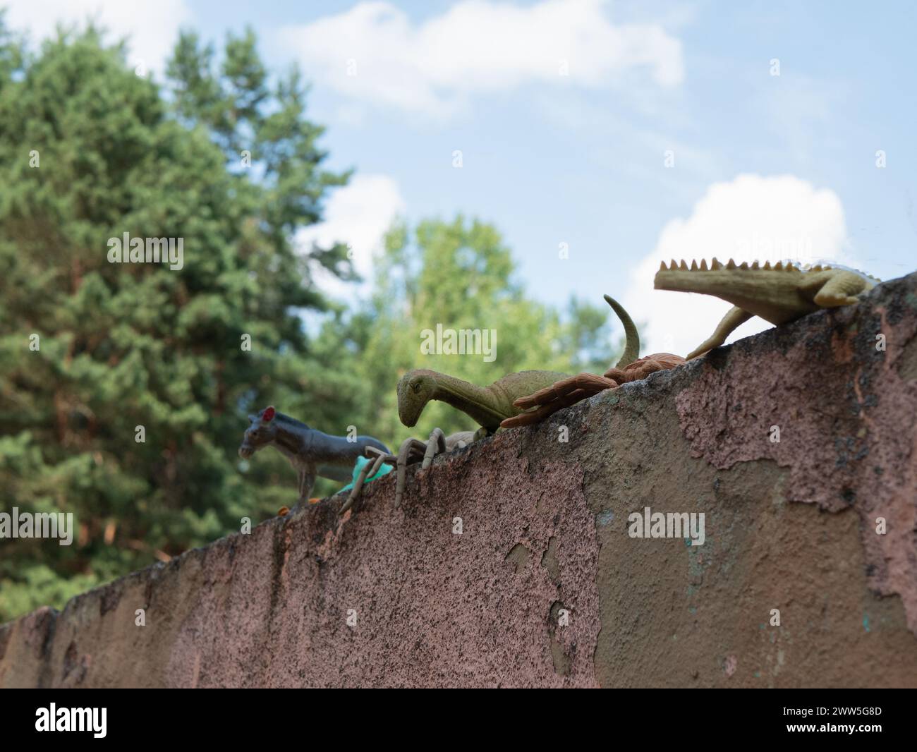 Abandoned figures of crocodile, donkey, dinosaur and spider, selective focus. Forgotten toys outdoors Stock Photo