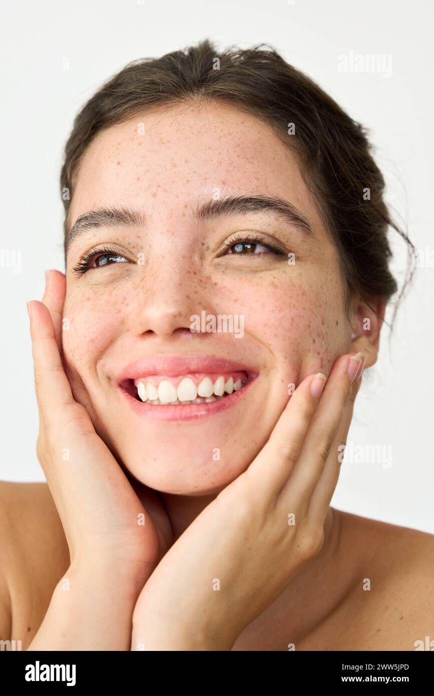 Happy Latin girl freckled face isolated on white background. Skin care concept. Stock Photo