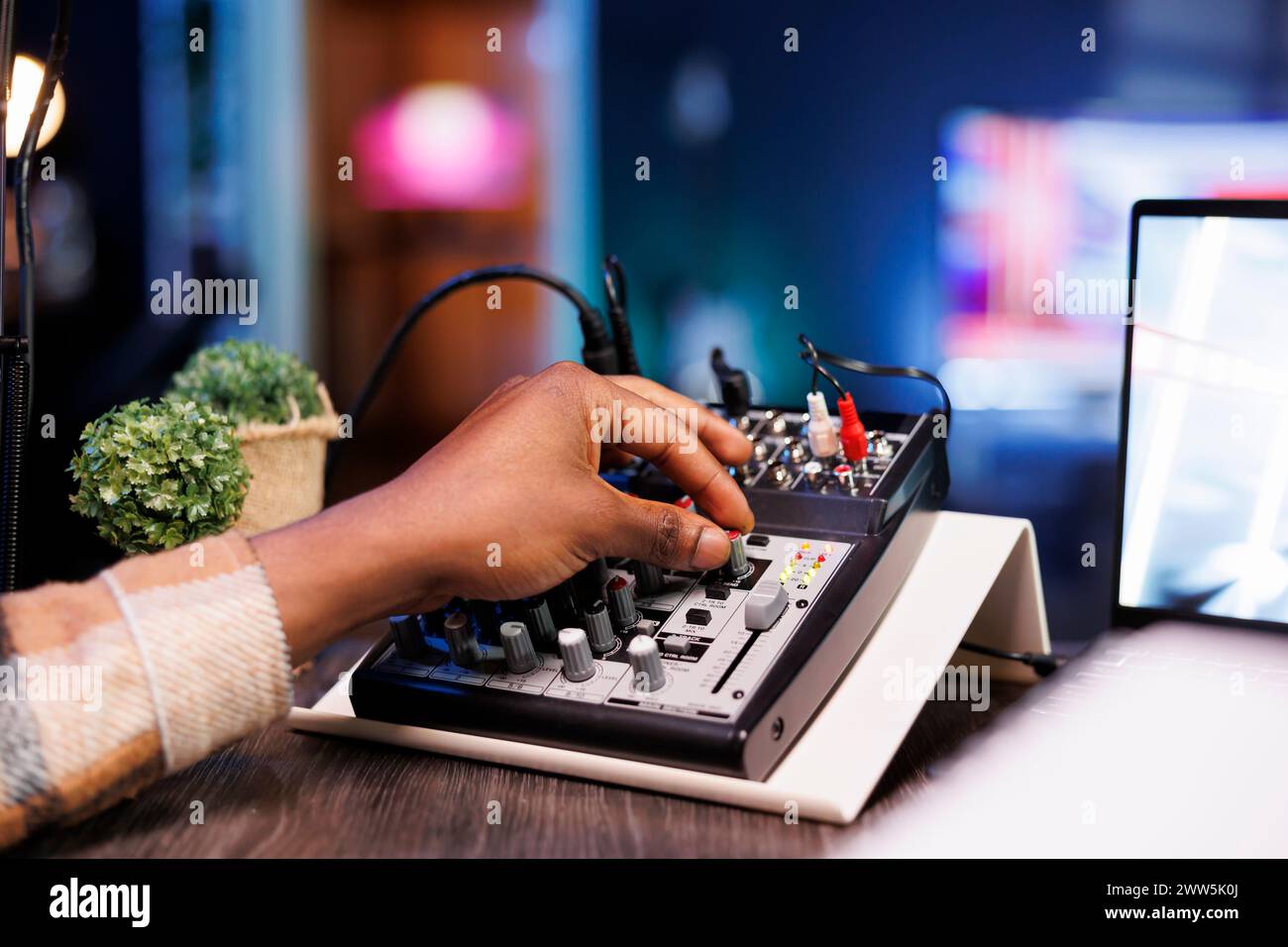 Detailed view of black person adjusting sound mixer to achieve high