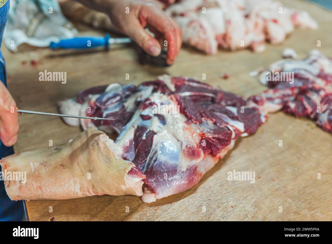 a man cutting pig meat on the table, butcher's work, processing pig meat. High quality photo Stock Photo