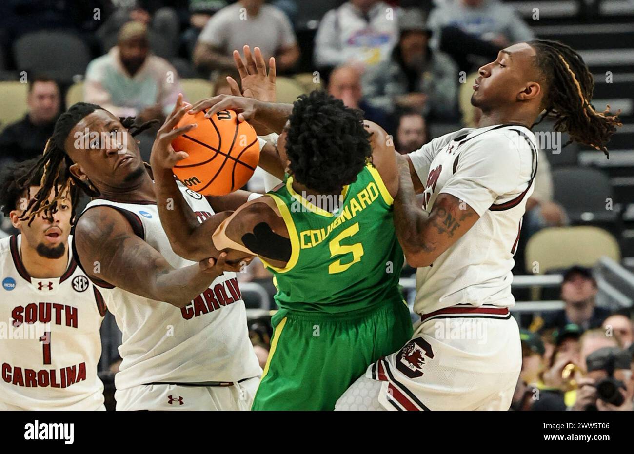 March 21, 2024: South Carolina Gamecocks forward B.J. Mack (left) and guard Zachary Davis (12) battle for a loose ball with Oregon Ducks guard Jermaine Couisnard (5) during the second half of play in the basketball game between Oregon Ducks (11) and South Carolina Gamecocks (6) in the first round of the NCAA Tournament game at the PPG Paints Arena in Pittsburgh, PA. Stock Photo