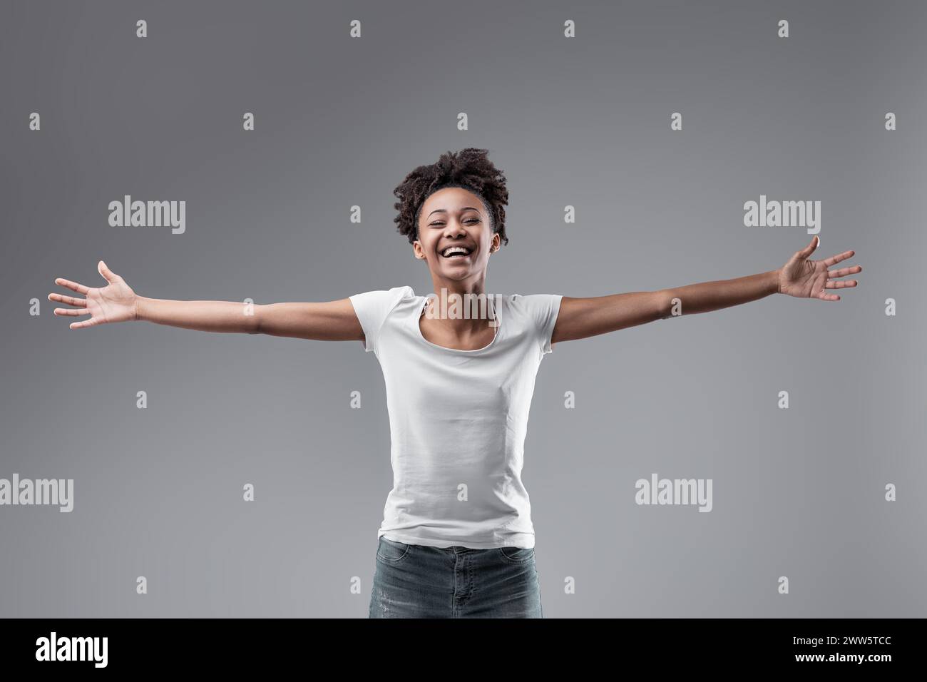 With open arms and a carefree smile, she presents a portrait of genuine happiness and openness Stock Photo