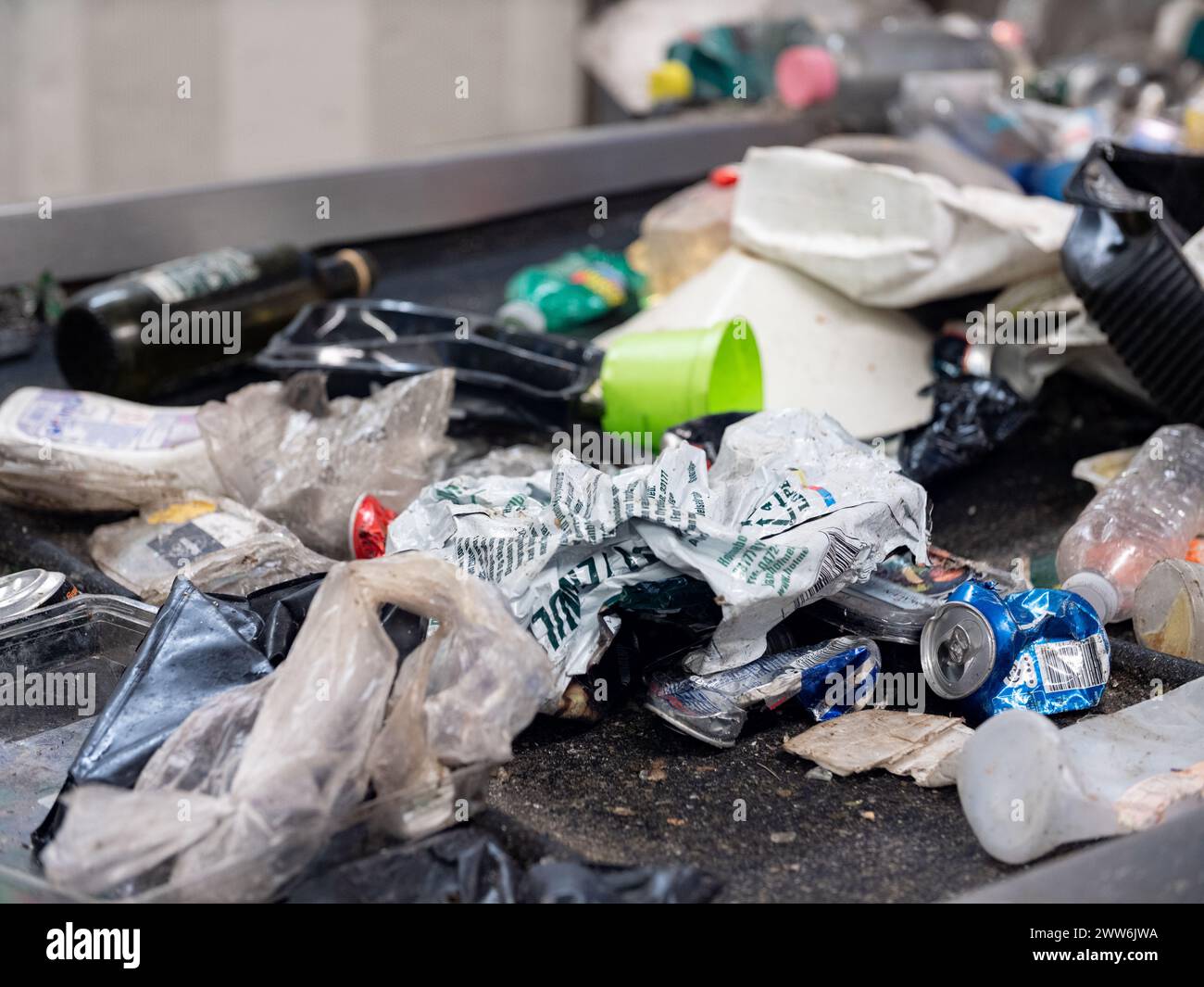 Plastic waste on a conveyor belt in a waste management plant Stock Photo