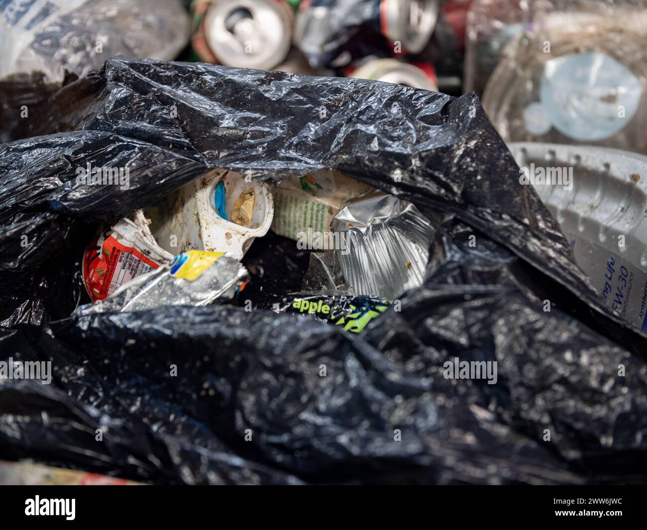 Household waste in a plastic bag on a conveyer belt in a treatment facility Stock Photo